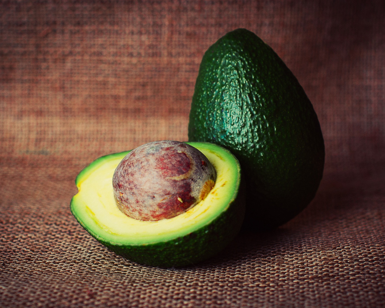 Большой зеленый плод авокадо с круглой косточкой