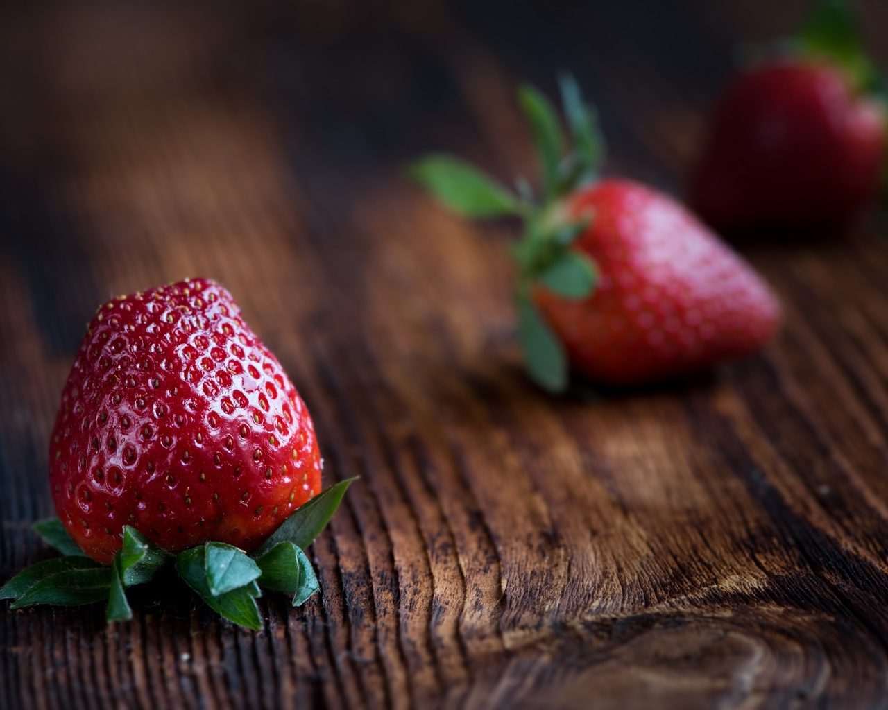 Большая крупная красная клубника на деревянном столе