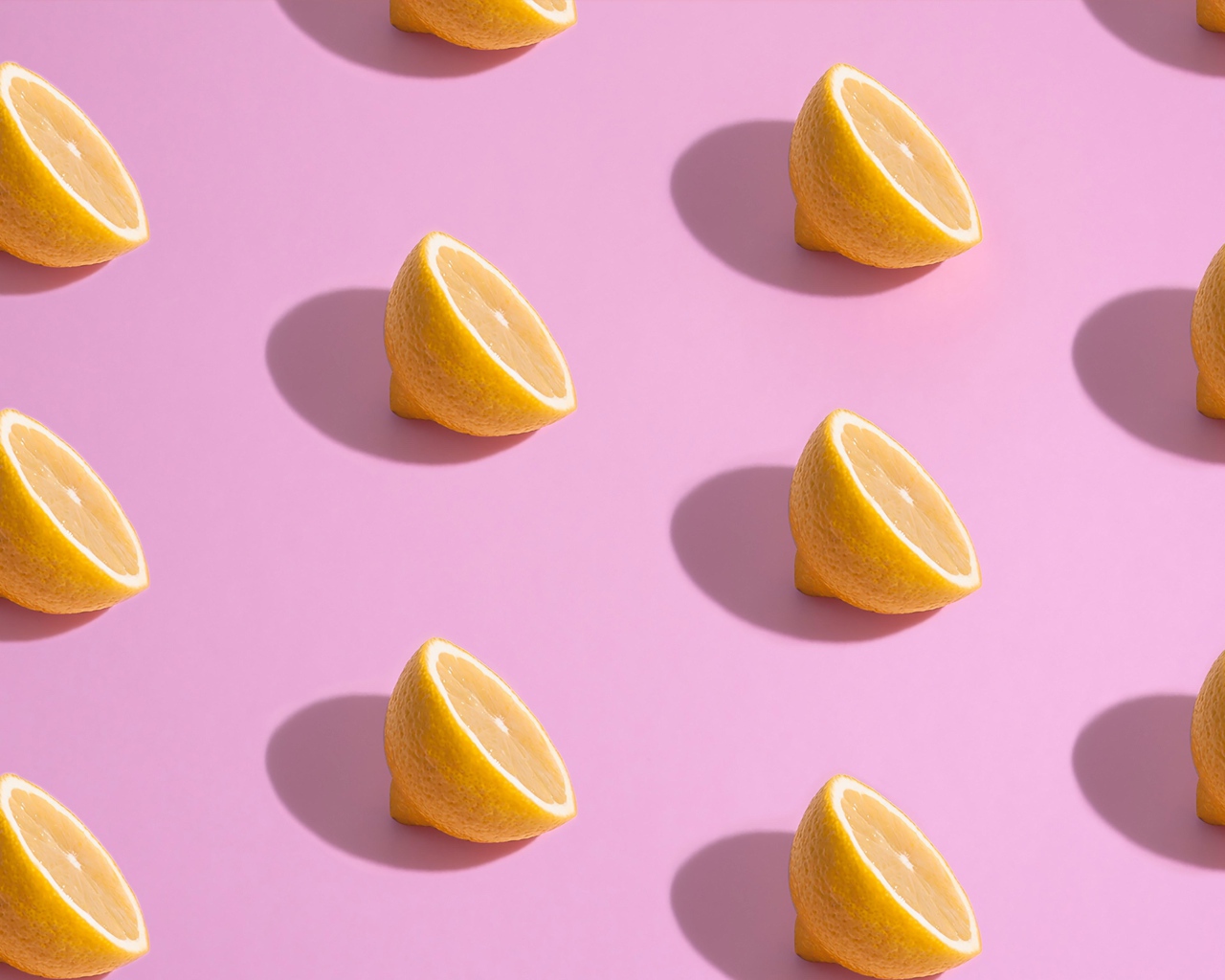 Половинки лимона на розовом фоне