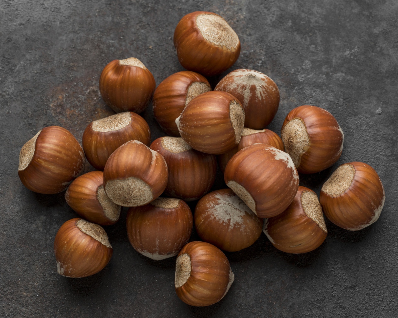Много лесных орехов на сером столе 