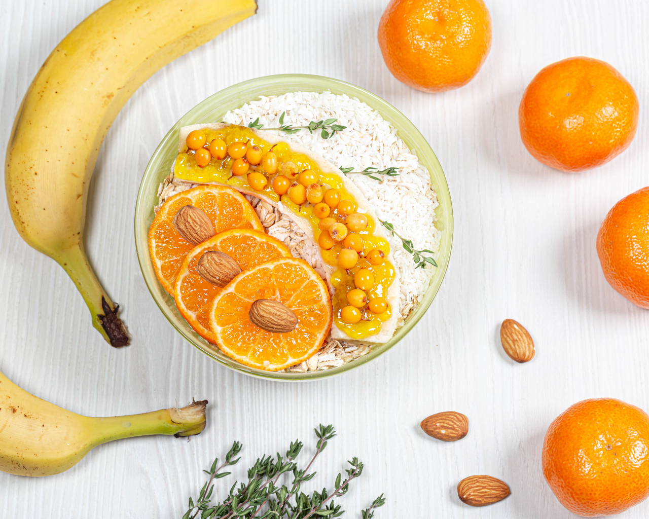 Мюсли с облепихой, бананом и апельсином на столе с фруктами