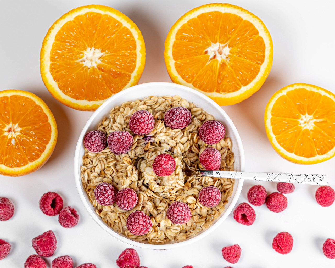 Овсяные хлопья с малиной на белом фоне с апельсинами