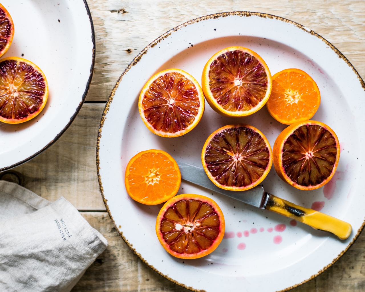 Половинки апельсина на тарелке с ножом