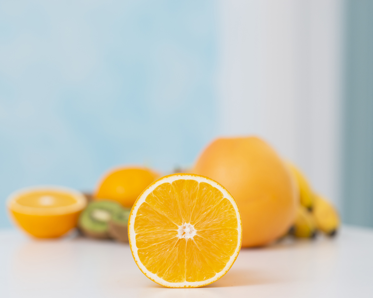 Оранжевые апельсины с киви на столе 