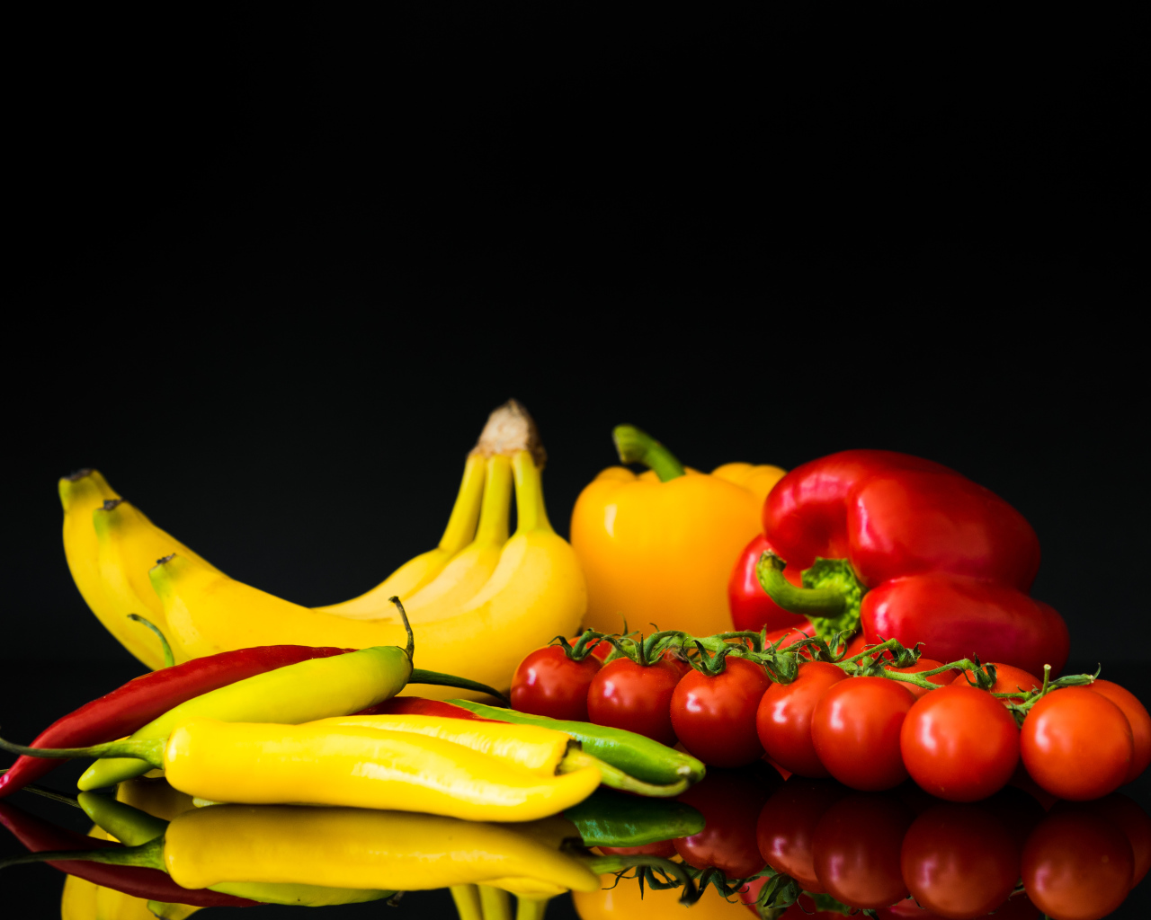 Перец, помидоры и бананы на черном фоне