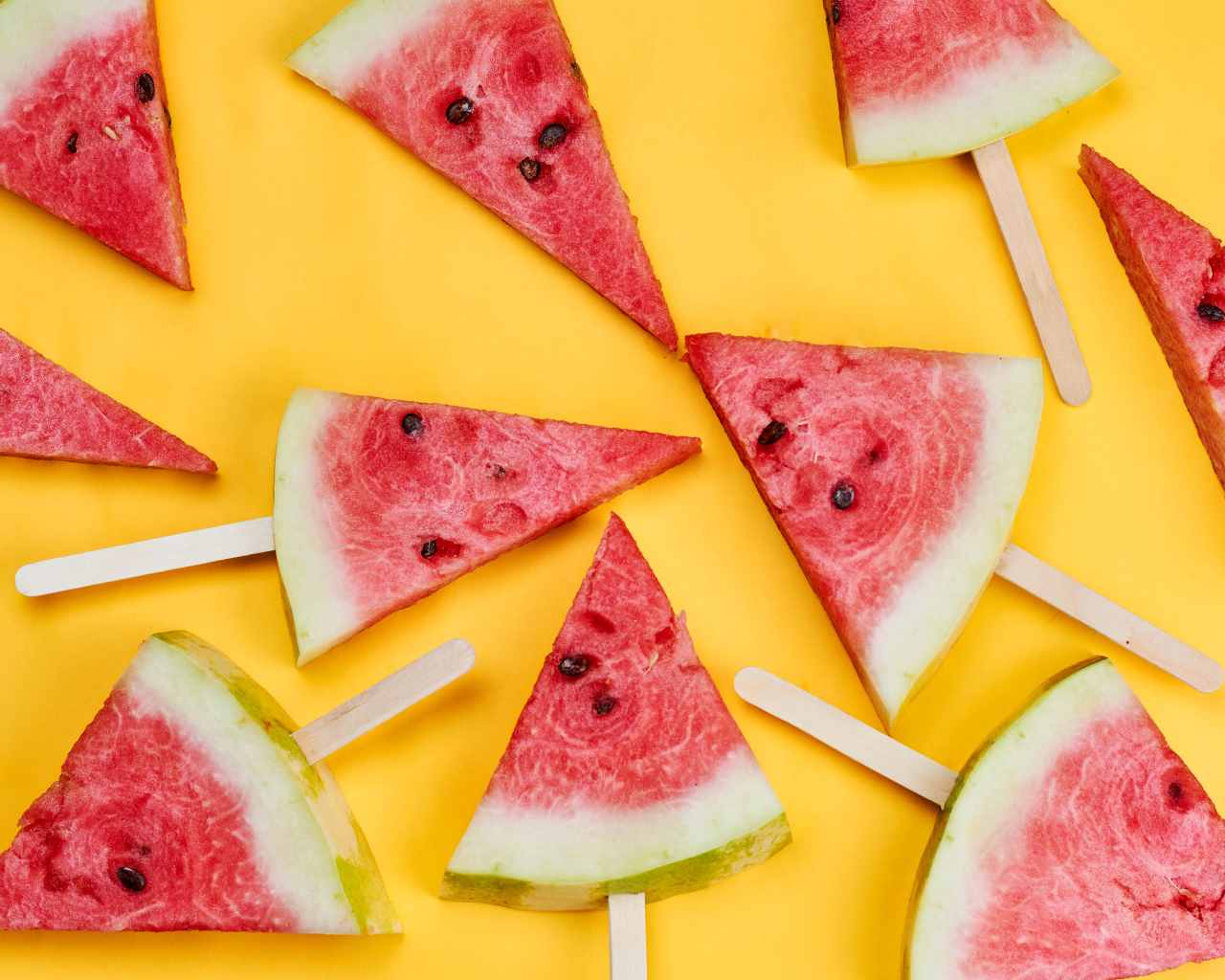 Кусочки арбуза на палочках на желтом фоне