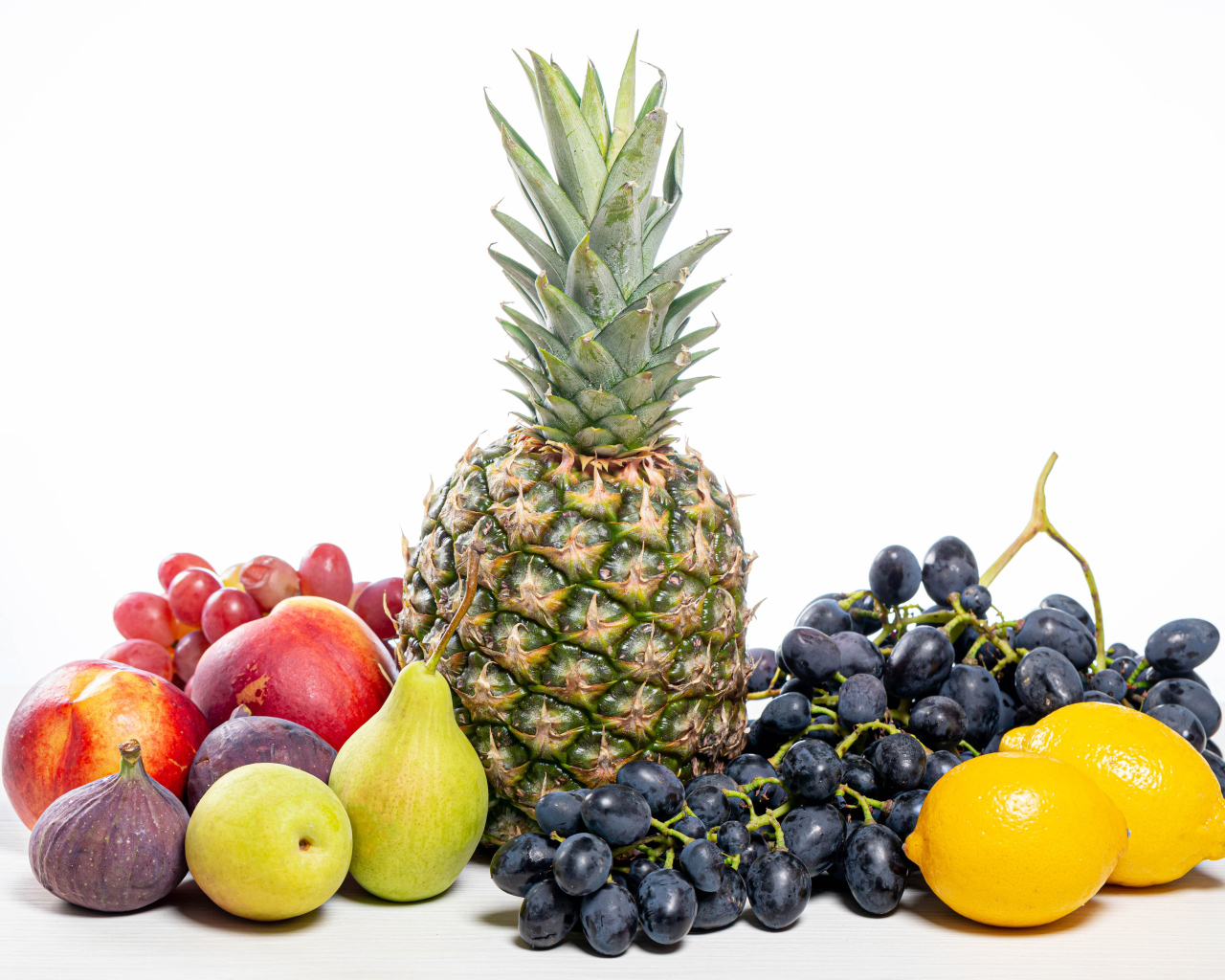 Ананас, виноград, инжир, лимон, нектарин и груши на белом фоне