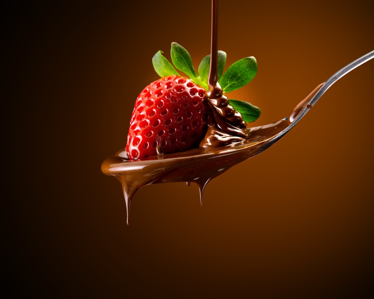 Красная клубника на ложке с молочным шоколадом