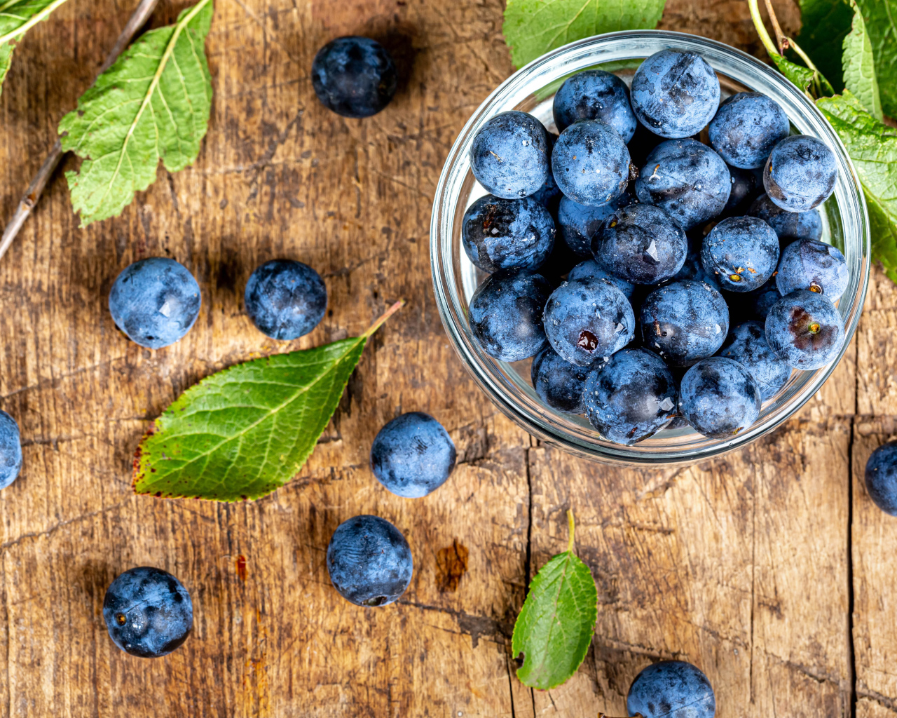 Спелые ягоды черники в стеклянной миске на столе 
