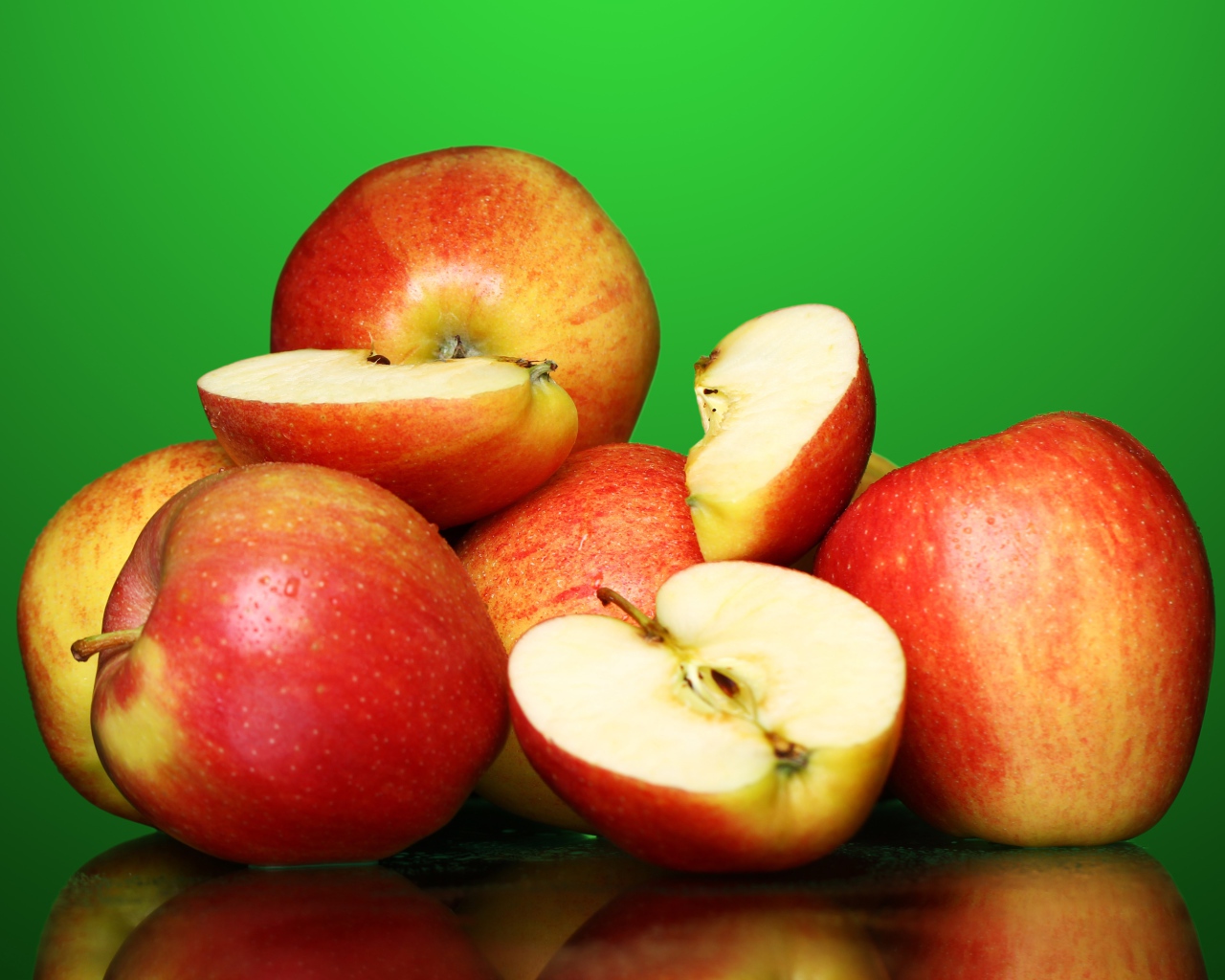 Спелые вкусные красные яблоки на зеленом фоне