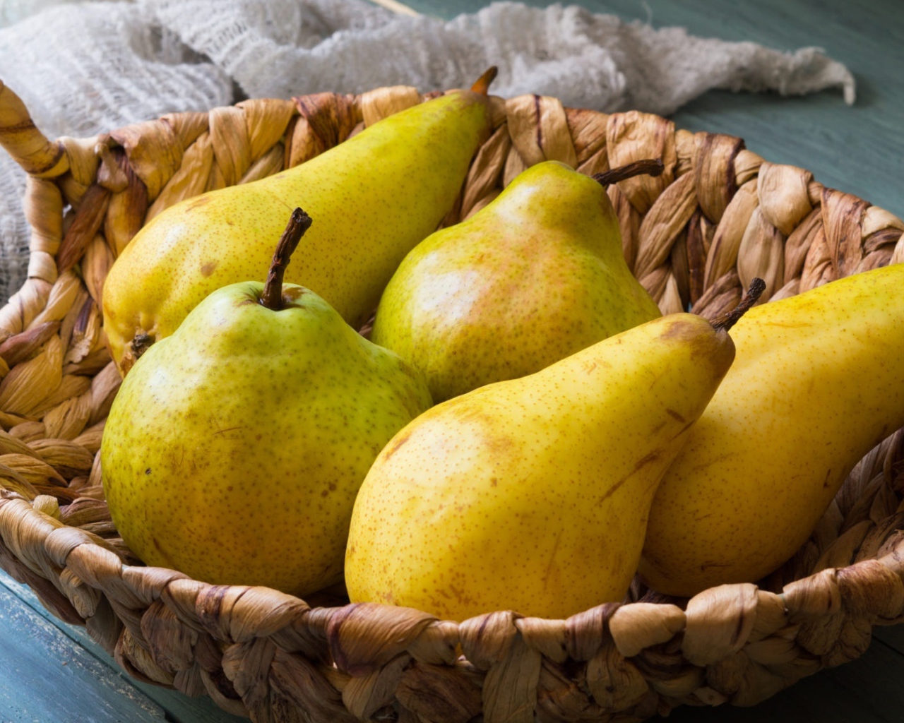 Спелые груши лежат в корзине на столе