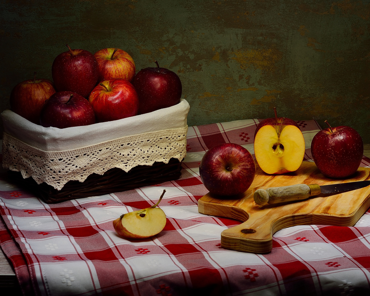 Спелые красные яблоки на столе с ножом