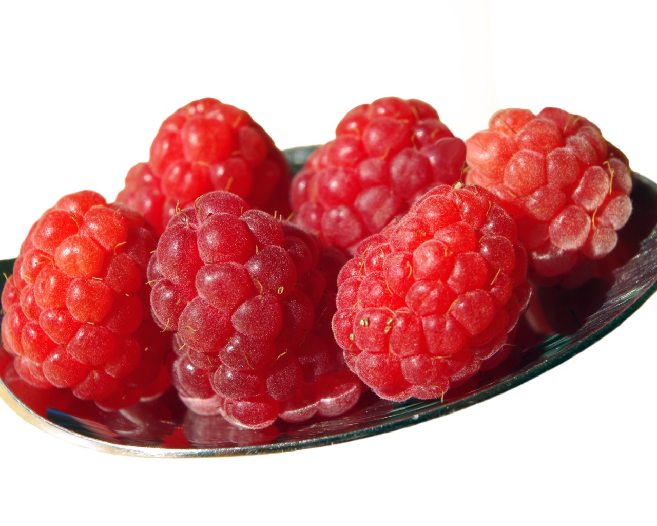 Спелая красная малина в ложке на белом фоне 