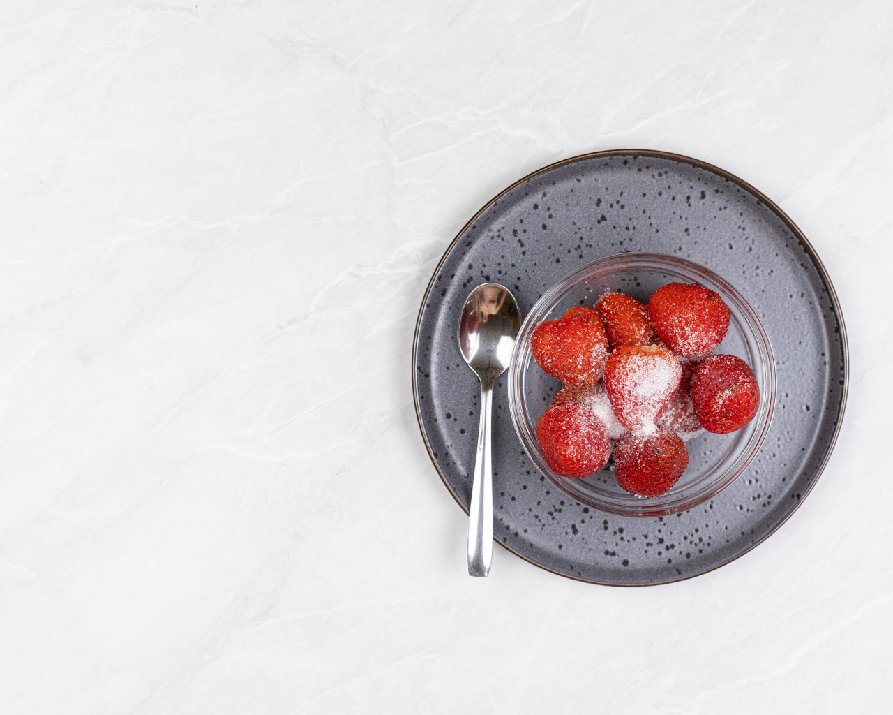 Спелая красная клубника в миске с сахаром на белом фоне