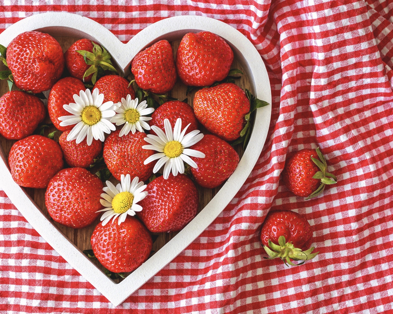 Спелая красная клубника в коробке в форме сердца с ромашками