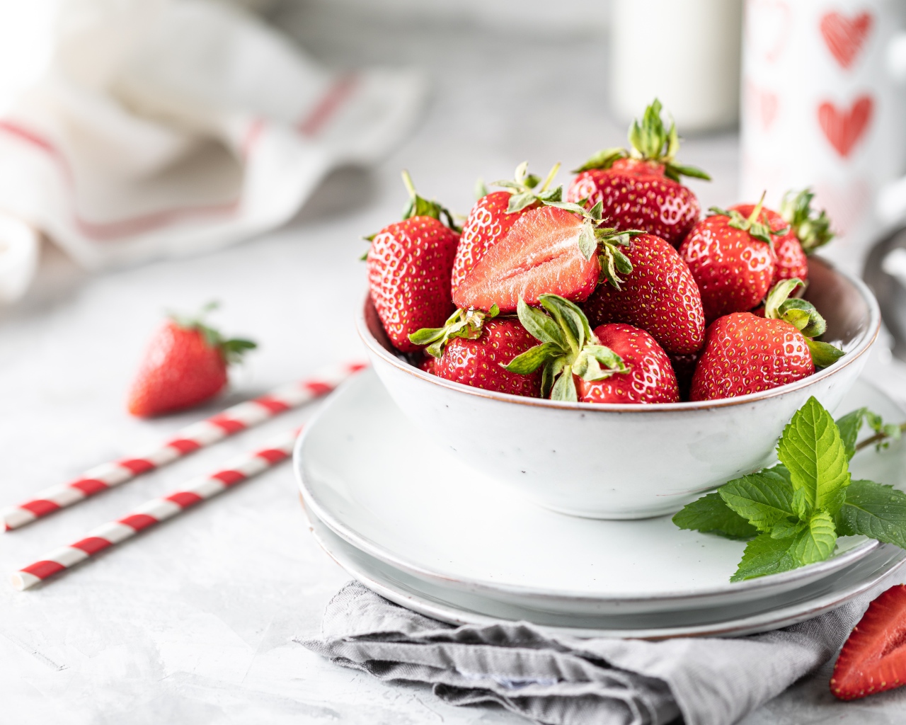 Спелая клубника в тарелке с листьями мяты