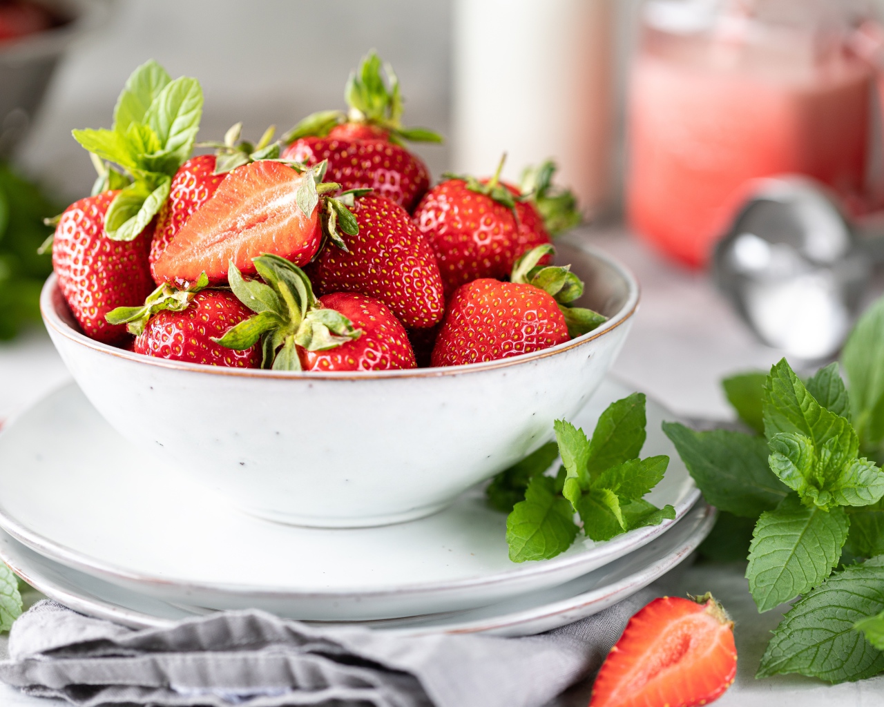 Спелая клубника с мятой на столе в белой тарелке 