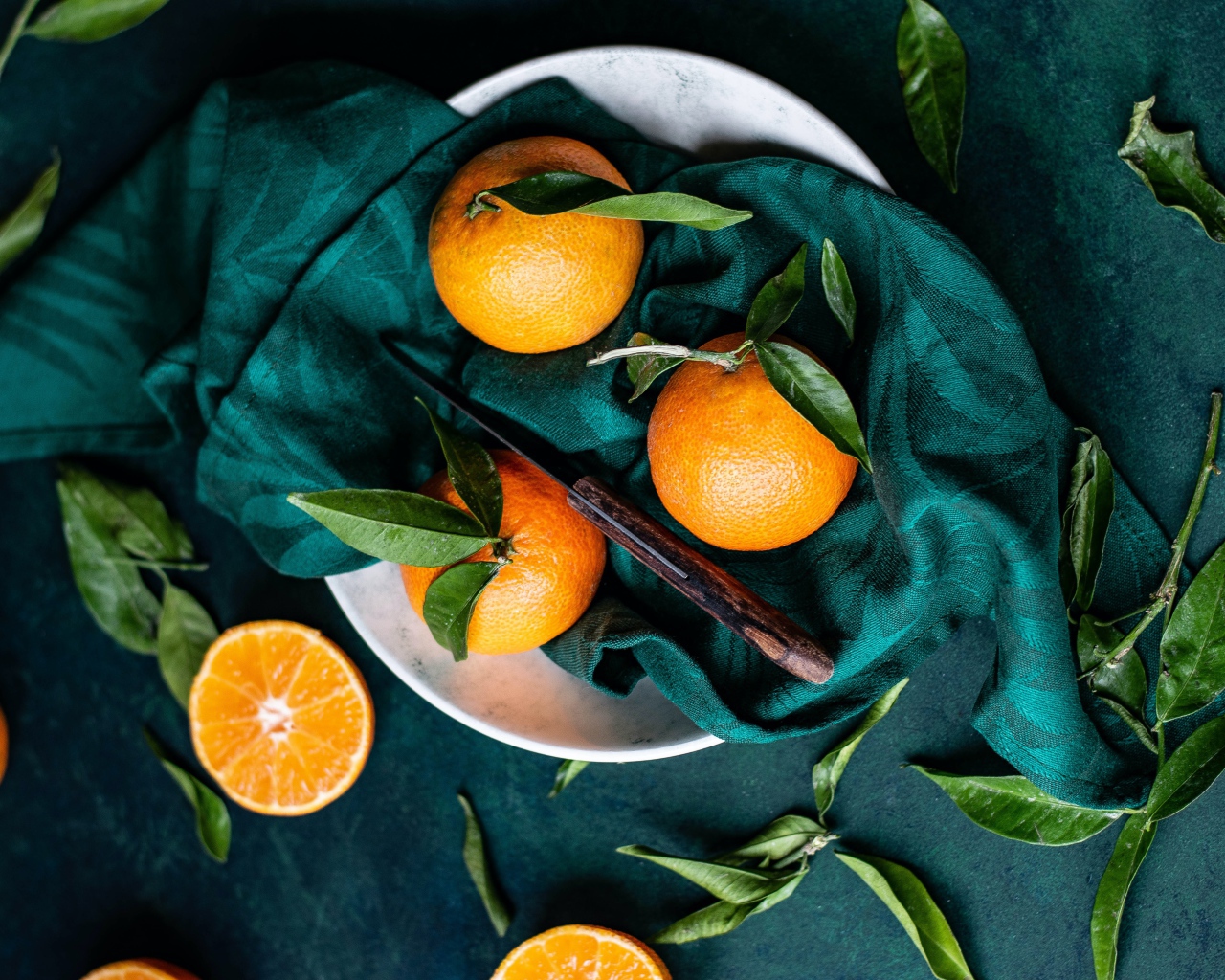Ripe tangerines on the table in a scarf