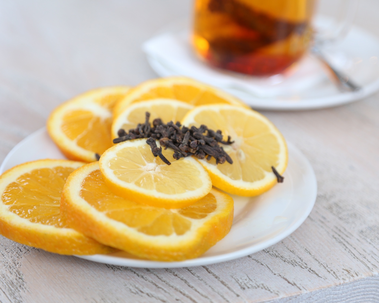 Sliced orange and lemon on a plate with cloves