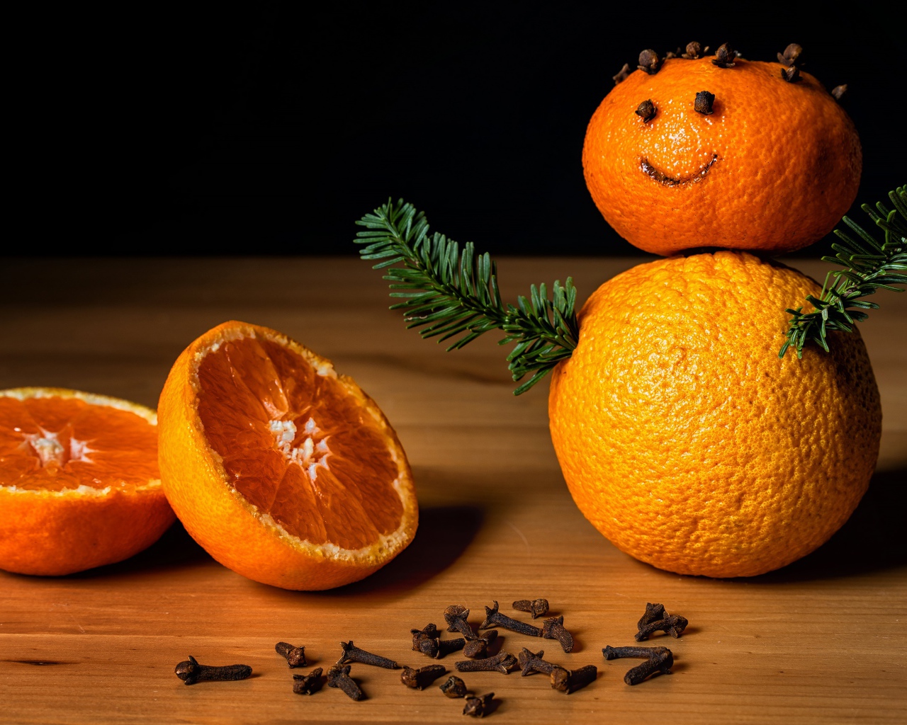 Снеговик из мандаринов и корицы на столе 