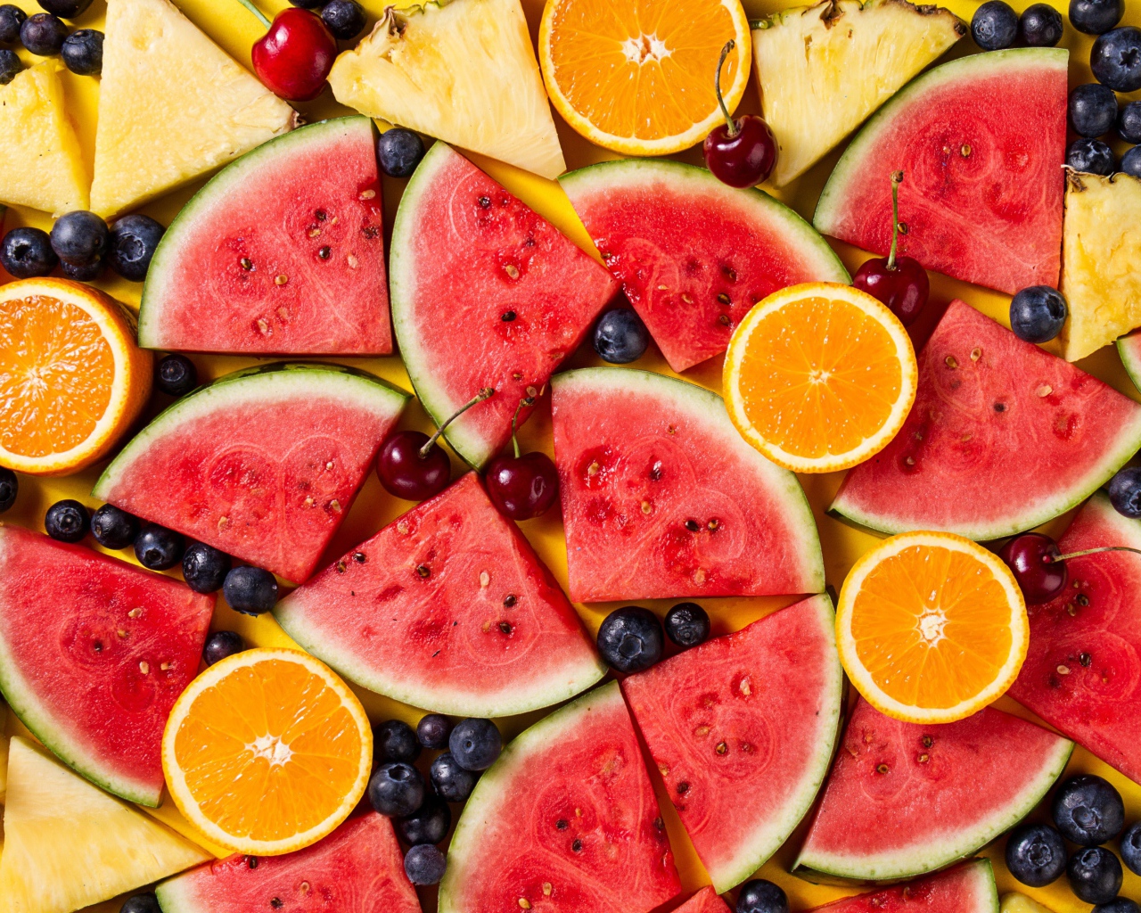 Вкусные свежие фрукты на желтом столе 