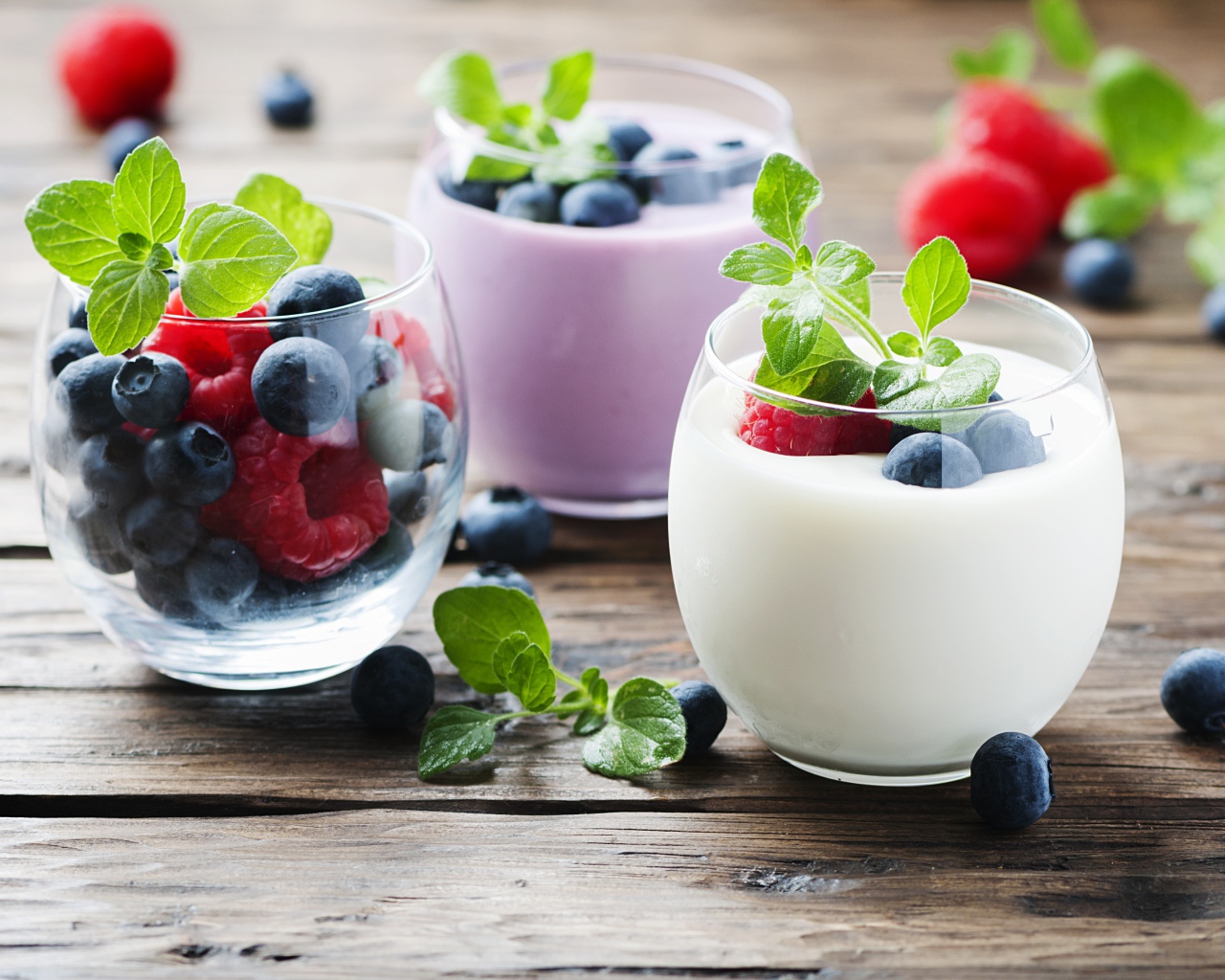 Вкусный йогурт с ягодами черники и малины на столе 