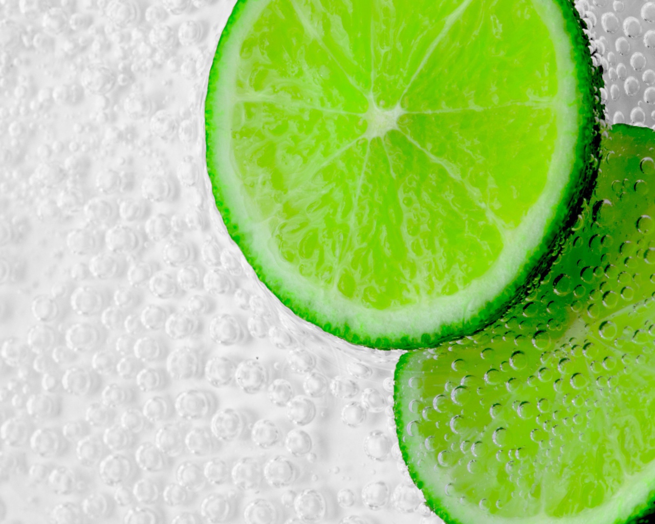Два куска лайма в пузырях в воде 