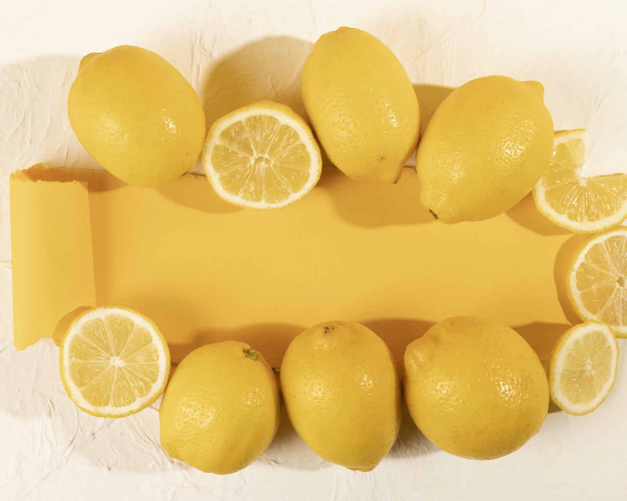 Желтые лимоны на белом фоне с листом бумаги