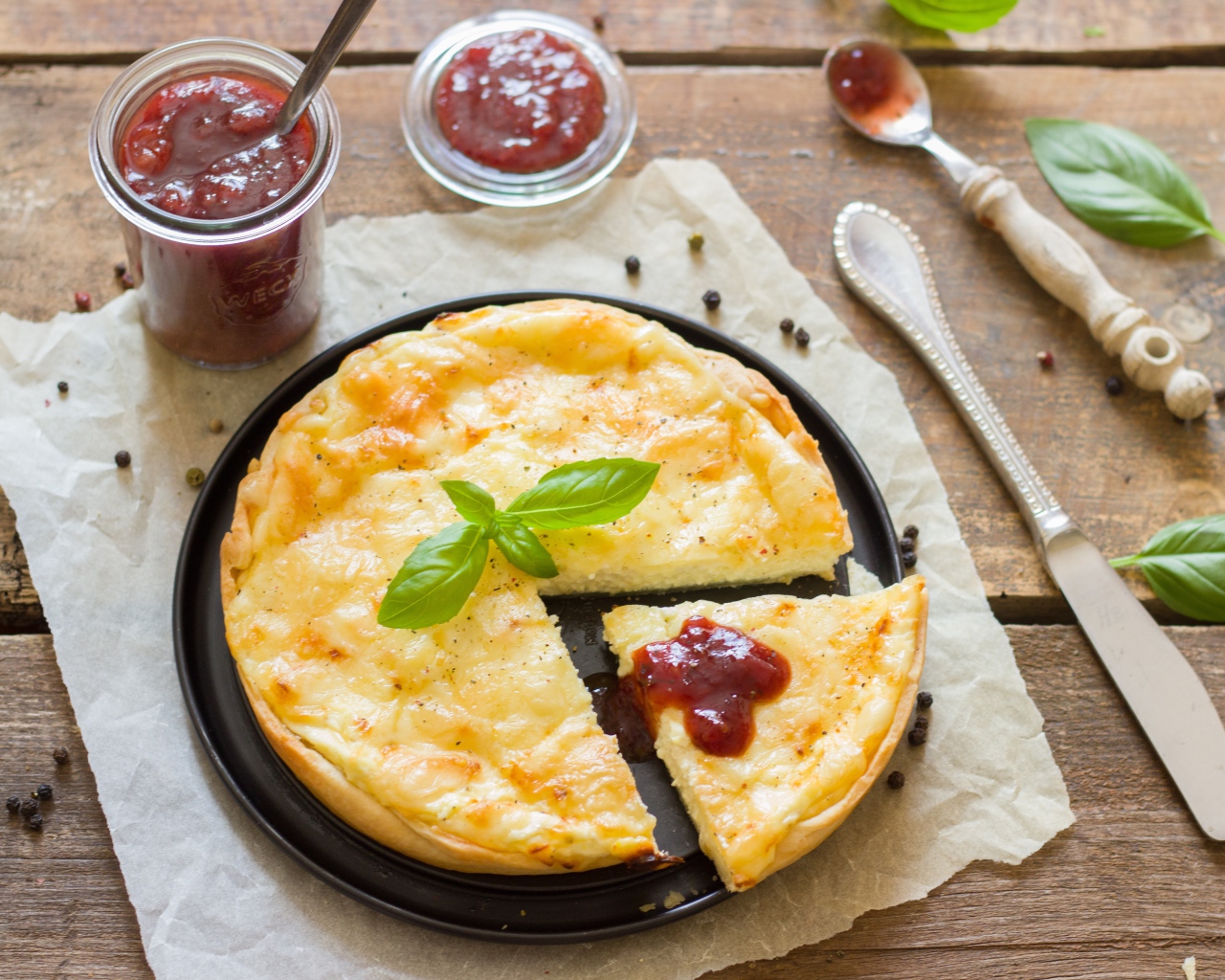 Пирог с сыром на столе с кетчупом и базиликом