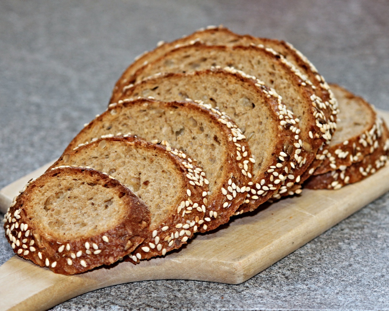 Свежий хлеб нарезан на доске на столе 