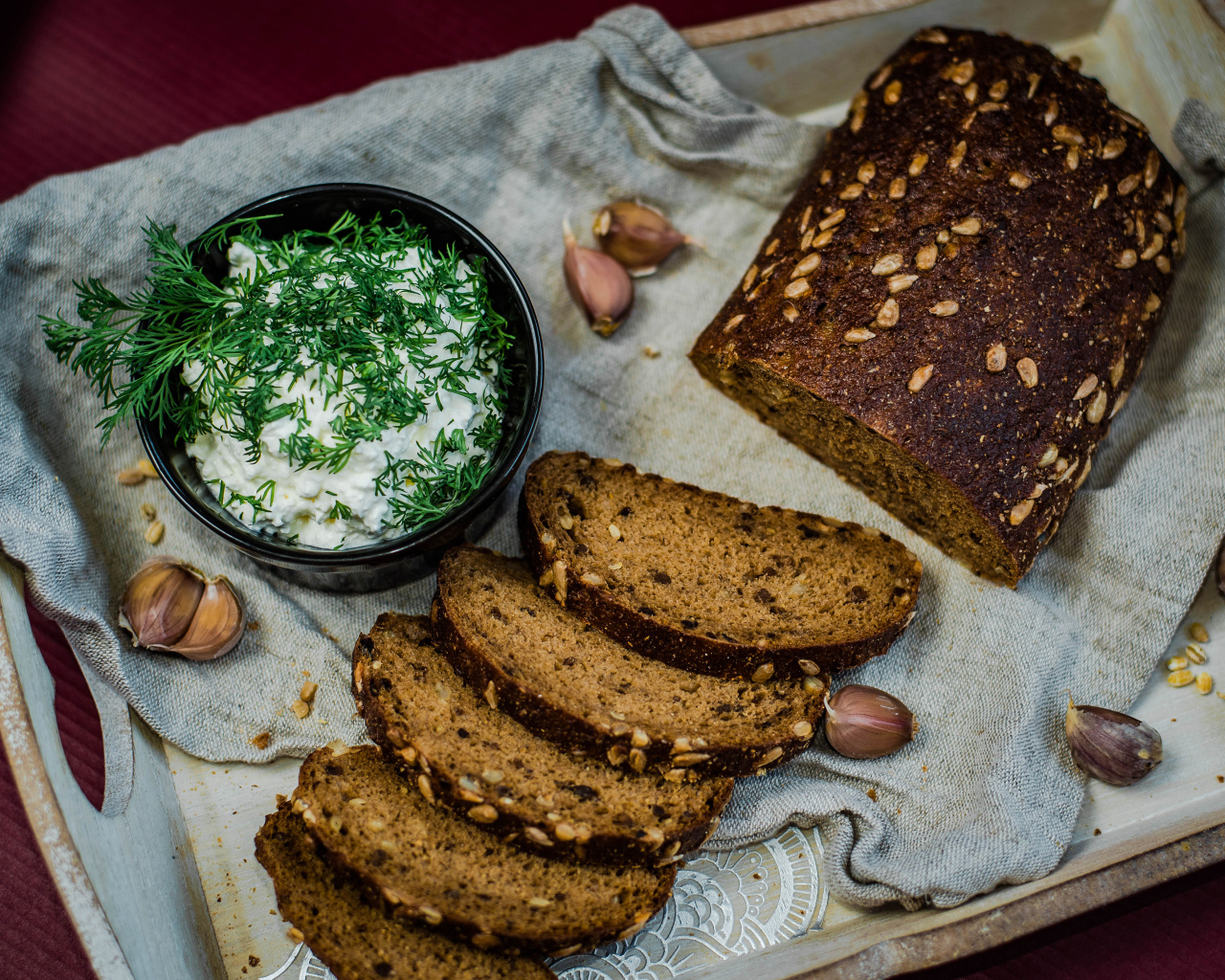 Свежий хлеб с зернами на столе с соусом и чесноком