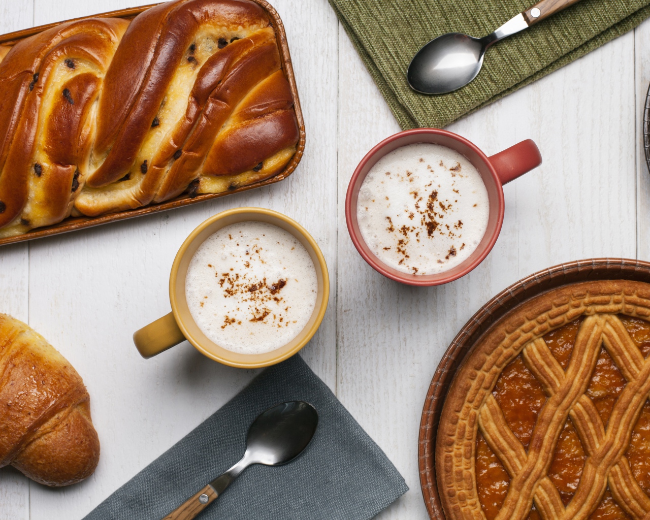 Свежая выпечка и две кружки молока на столе