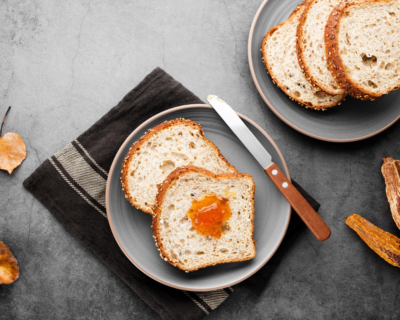 Куски хлеба с джемом на сером столе 