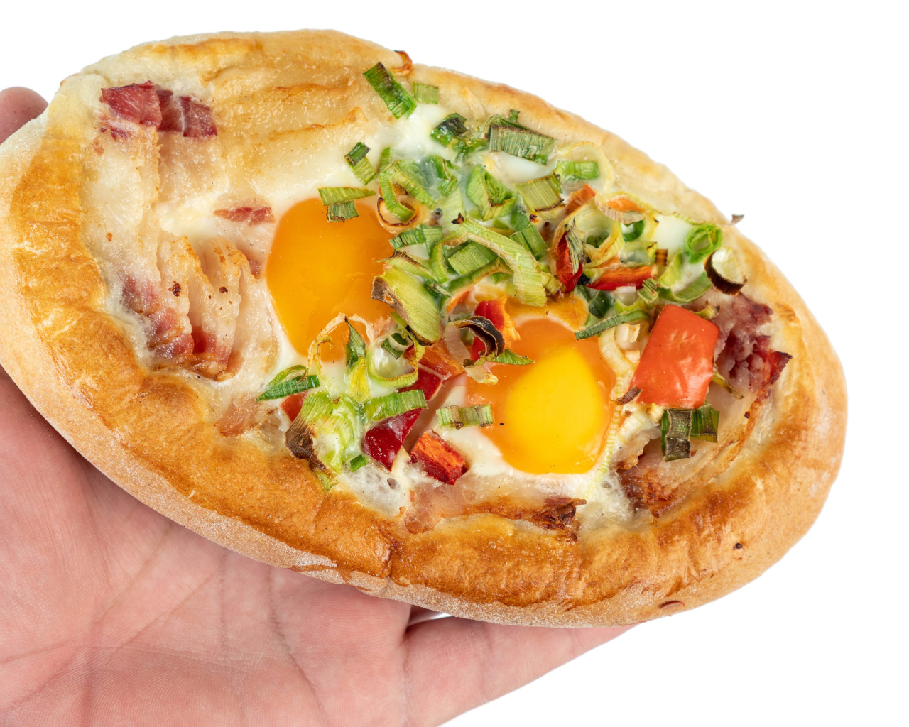 Вкусный свежий хачапури с яйцом и беконом в руке