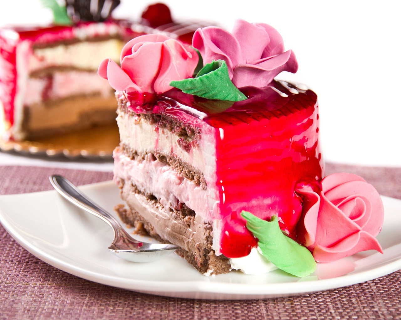 Кусок аппетитного торта декорирован розами из крема