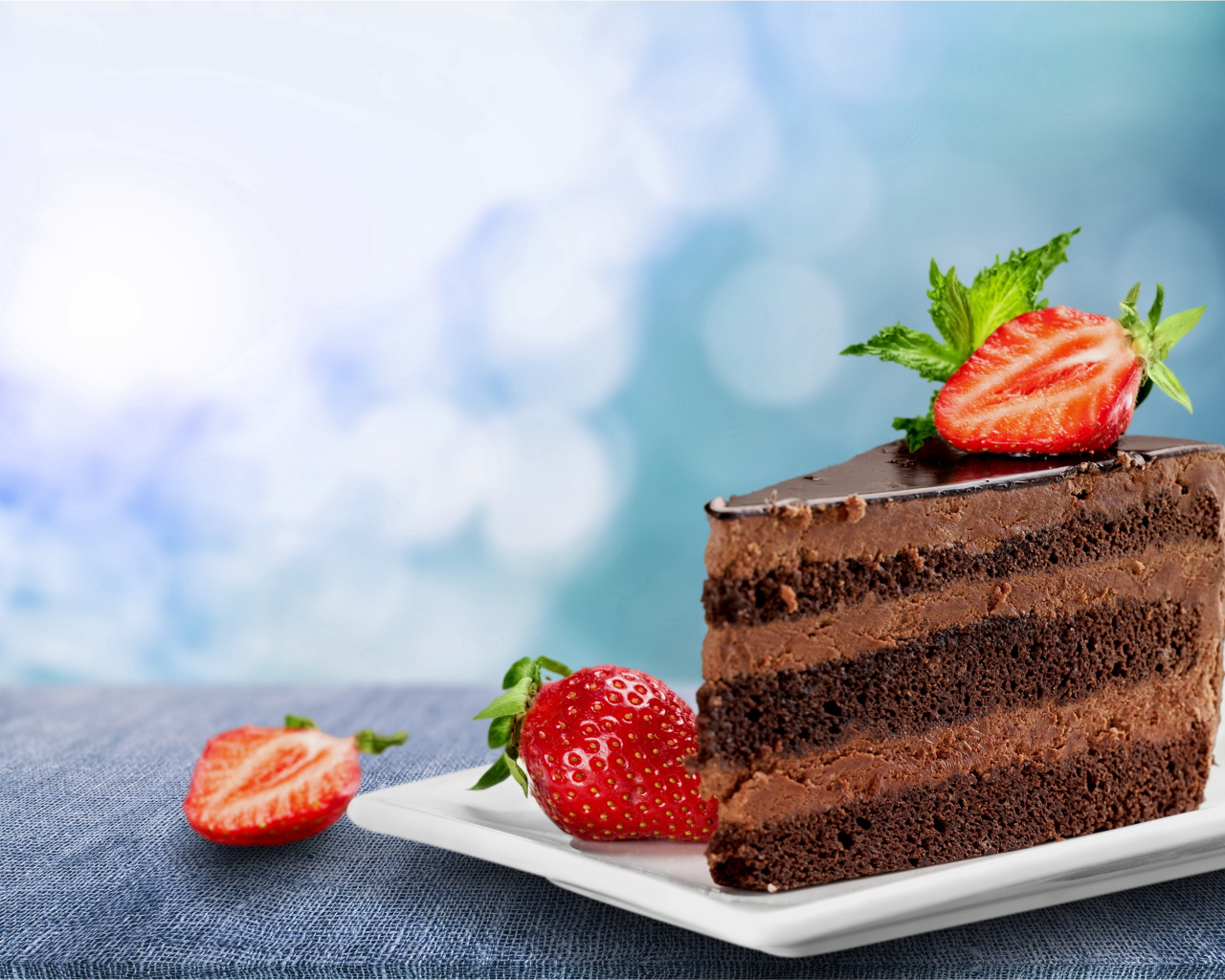 Кусок аппетитного торта с шоколадным кремом и клубникой 