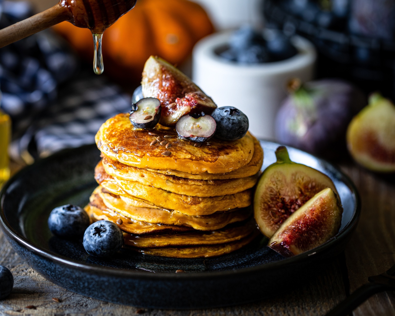 Аппетитные оладьи на тарелке с ягодами черники и инжиром