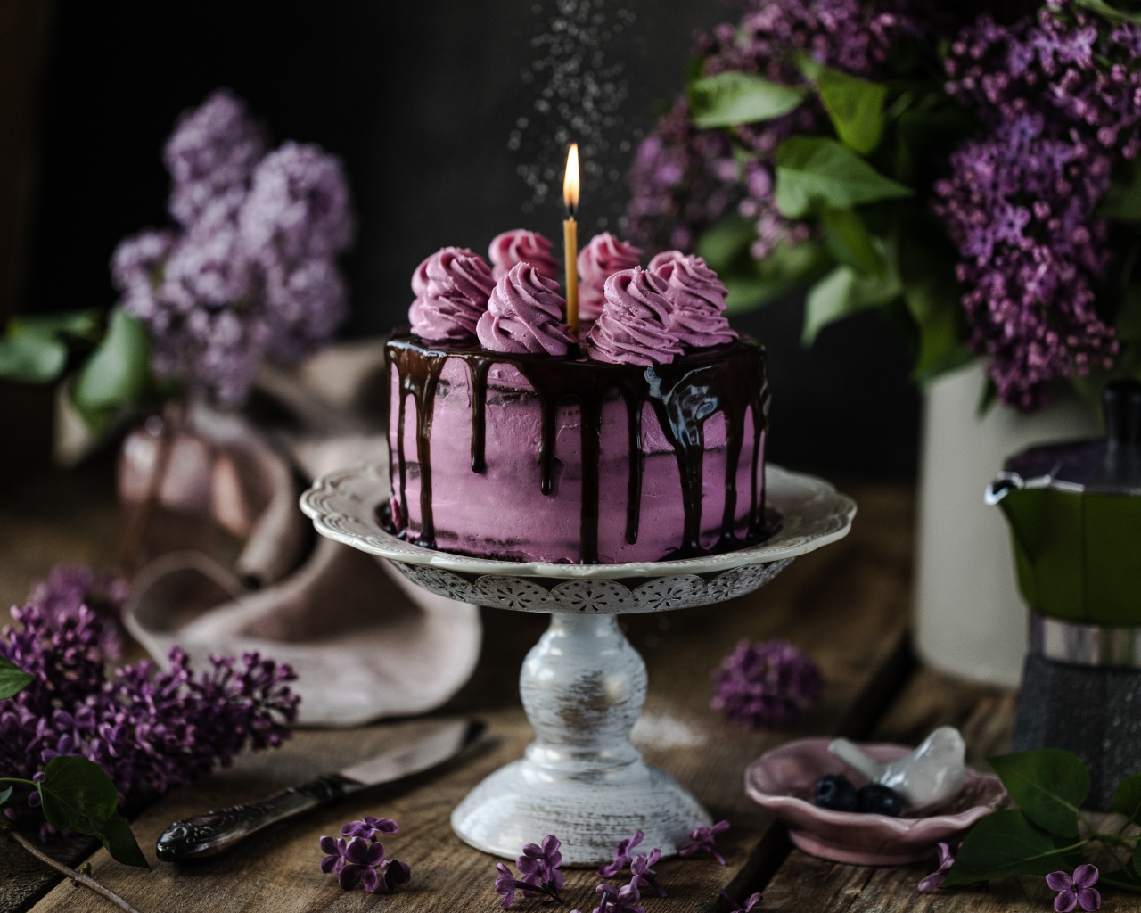 Ягодный торт со свечой на столе с сиренью 