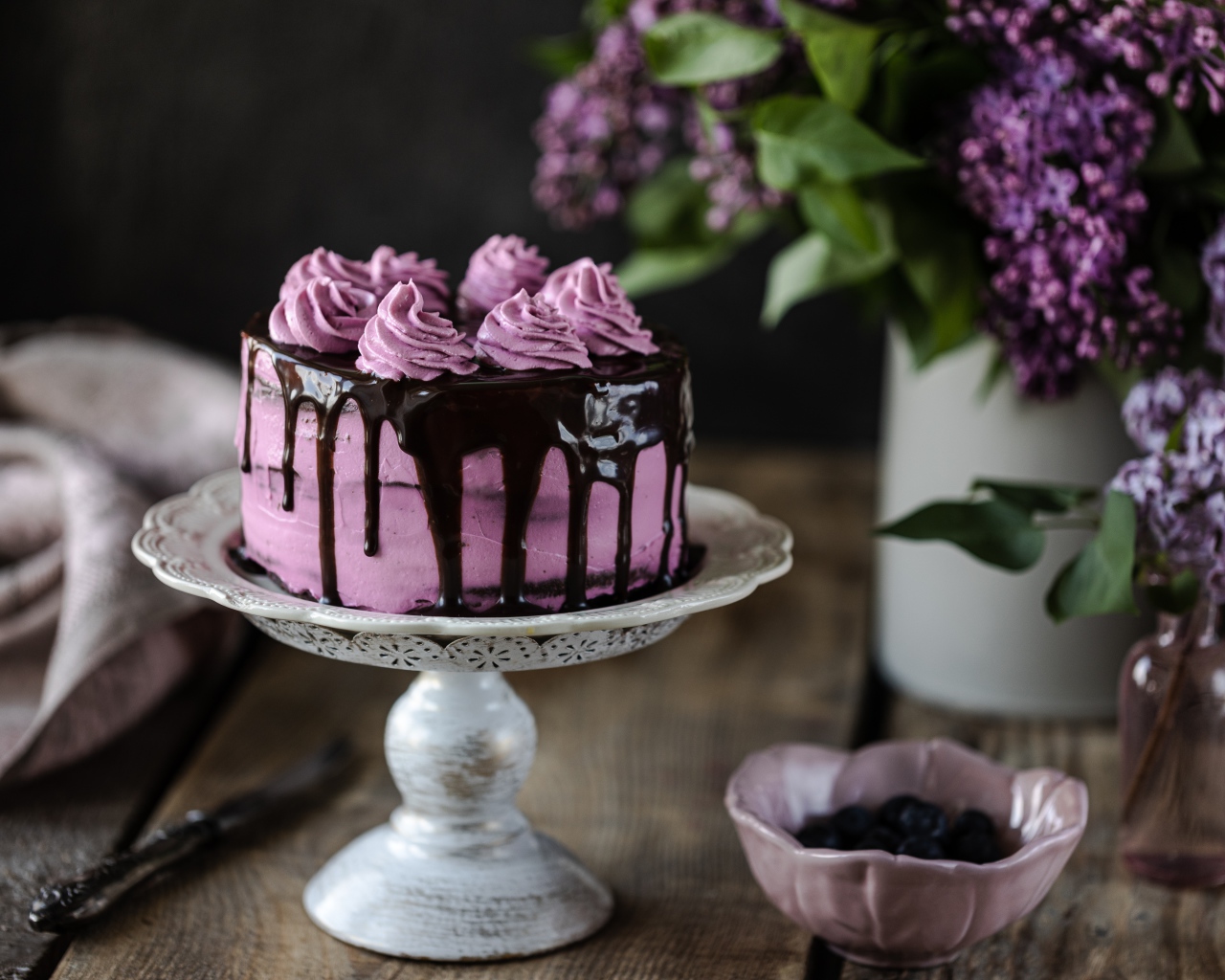 Ягодный торт с шоколадом на столе с сиренью 