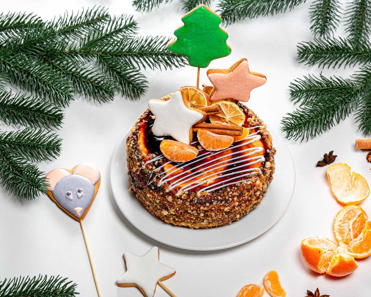 Торт с мандаринами и печеньем на столе с еловой веткой