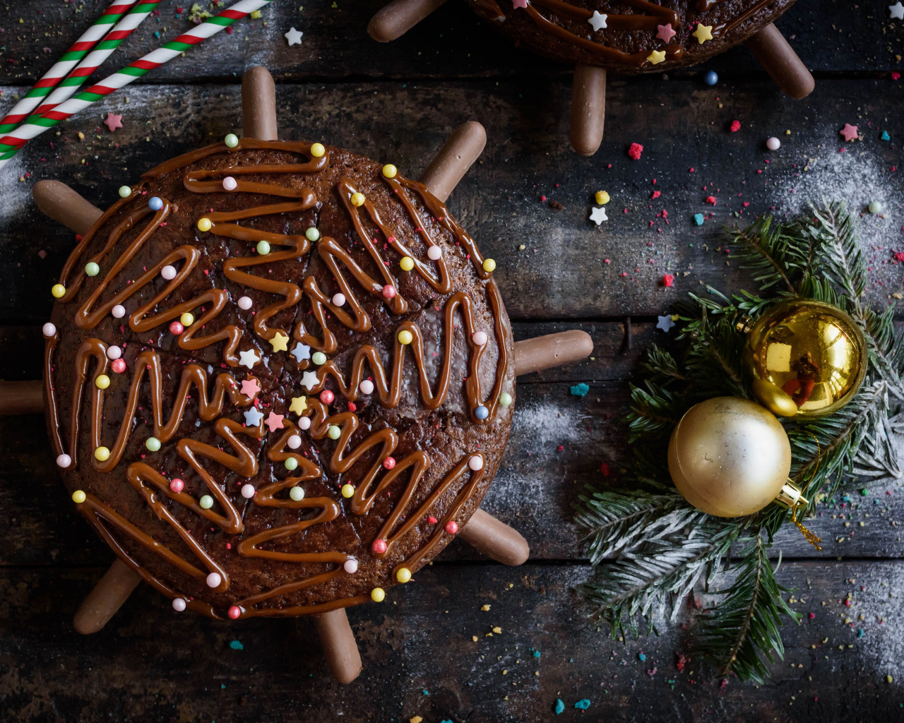 Шоколадное пирожное на столе с еловыми игрушками 