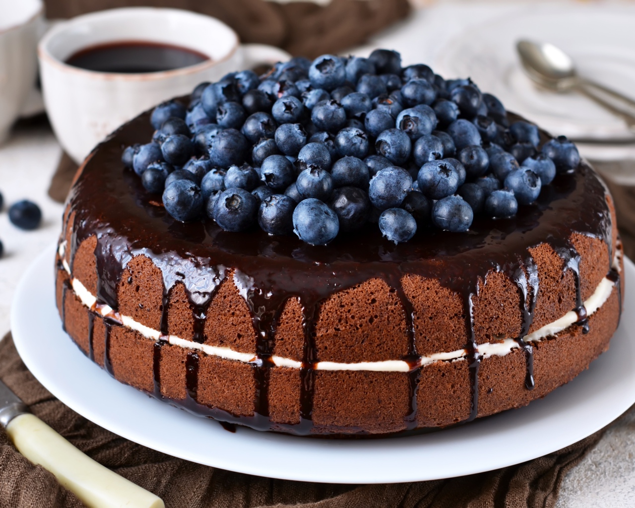 Шоколадный пирог с ягодами черники  на столе с кофе