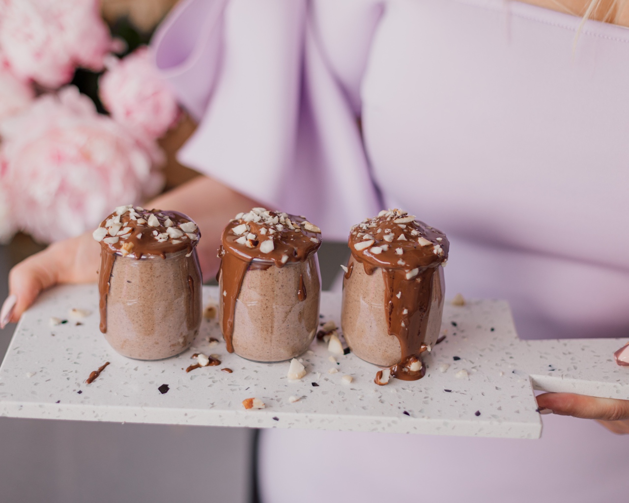 Шоколадный десерт в банках в руках у девушки