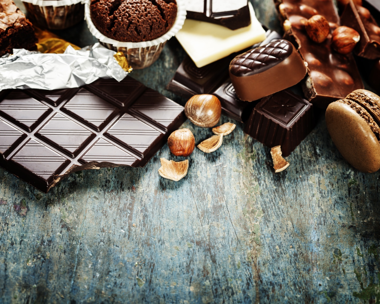 Шоколад на столе с орехами, кексами и конфетами 