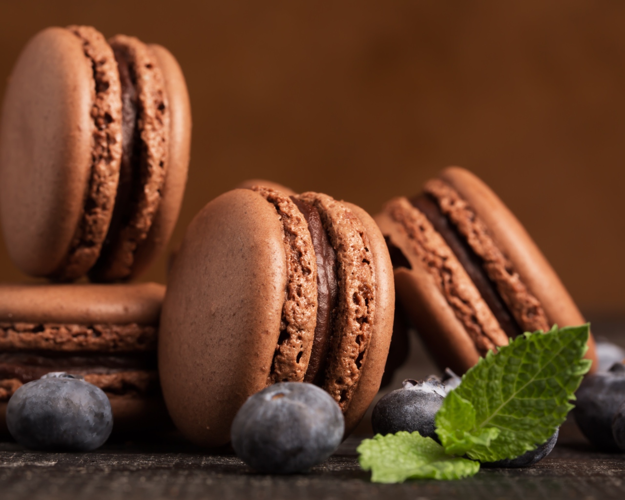Шоколадный десерт макарон на столе с черникой 