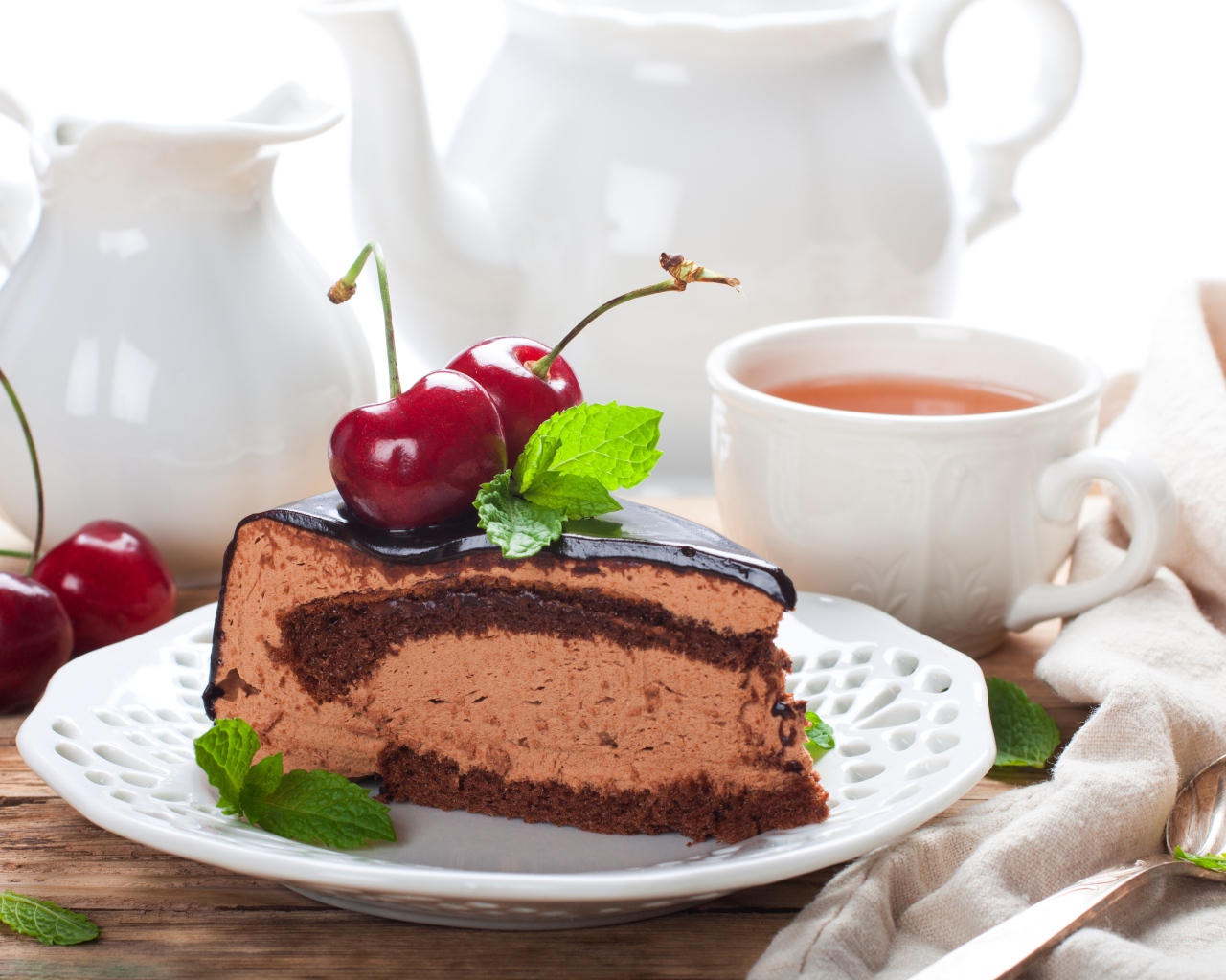 Торт с суфле в шоколаде с ягодами черешни на столе с чаем