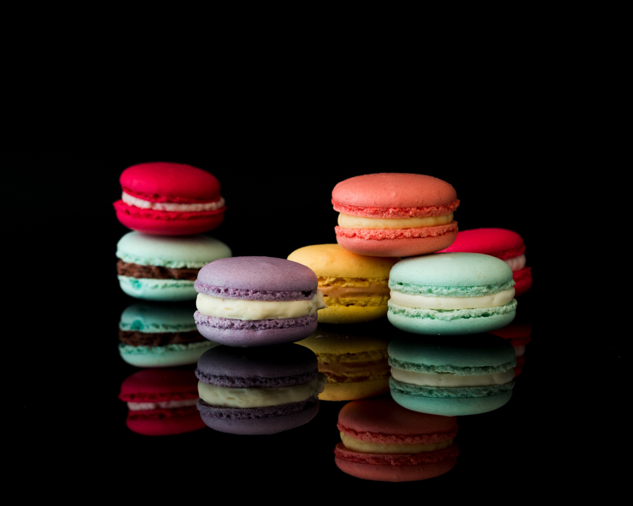Разноцветный десерт макарун на черном фоне