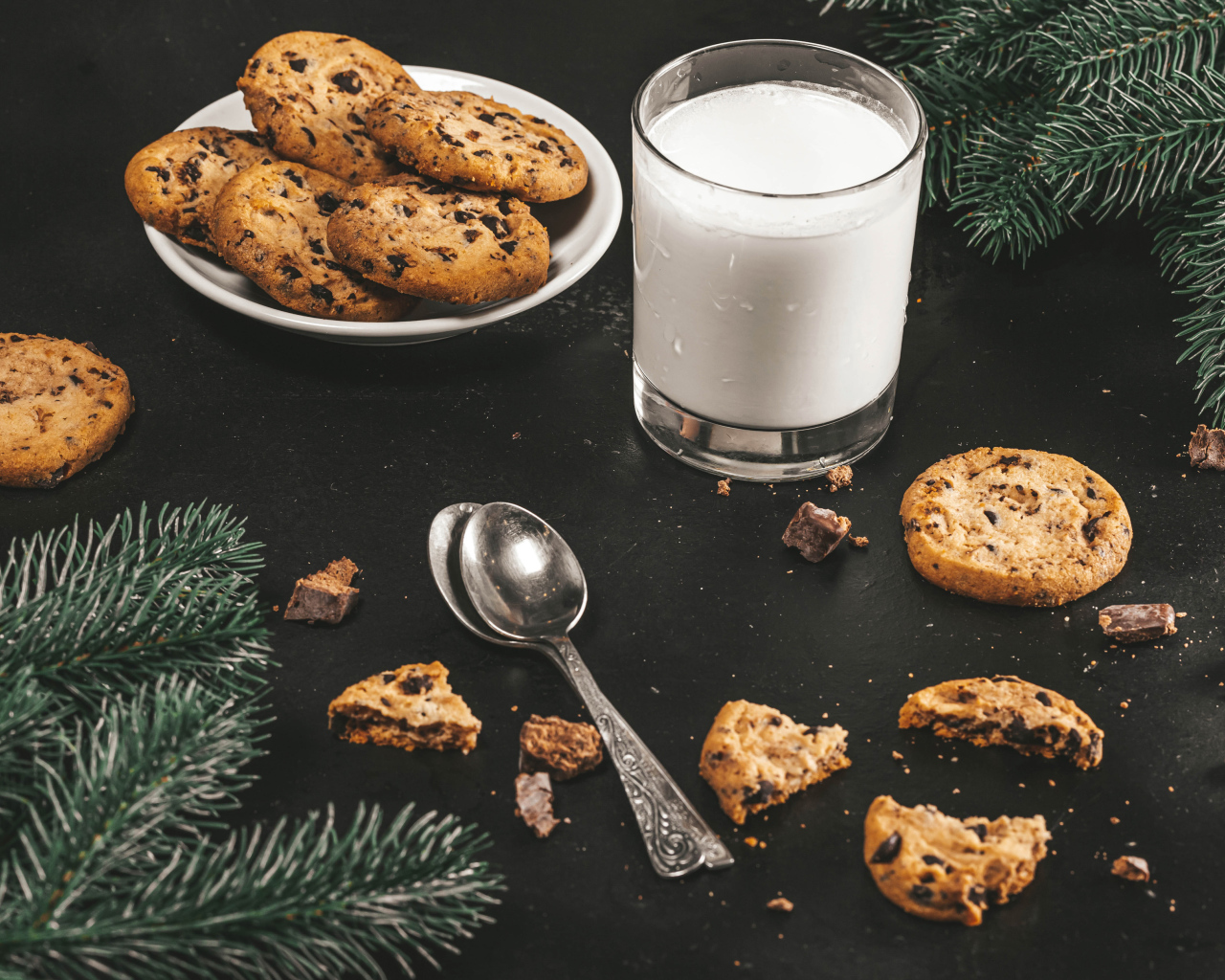 Печенье на столе с молоком и еловыми ветками