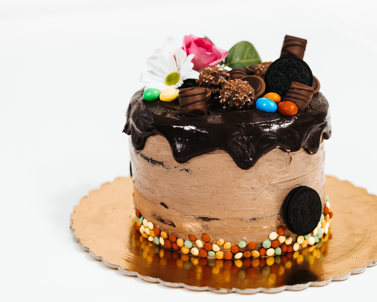 Торт с кремом и шоколадом украшен сладостями