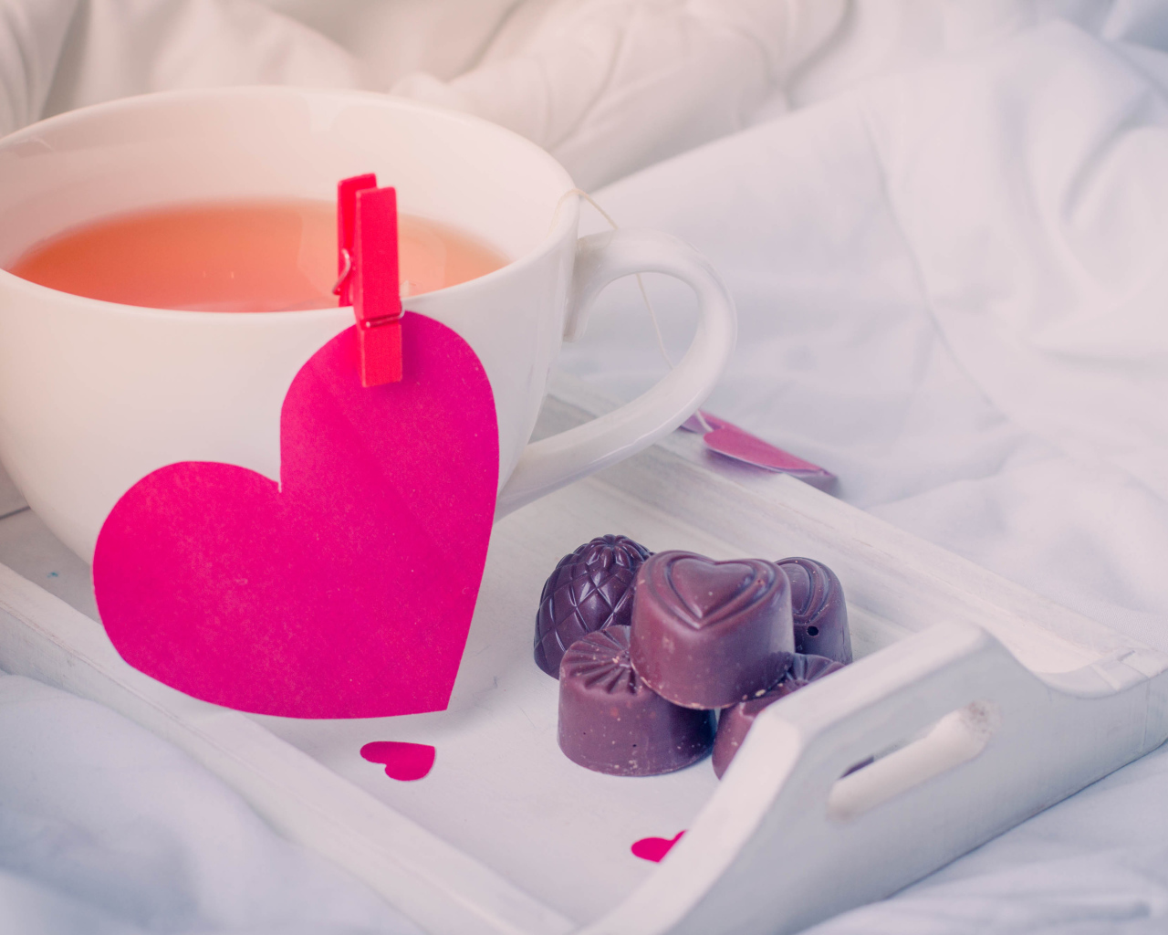 Чашка кофе с красным сердцем и шоколадными конфетами 